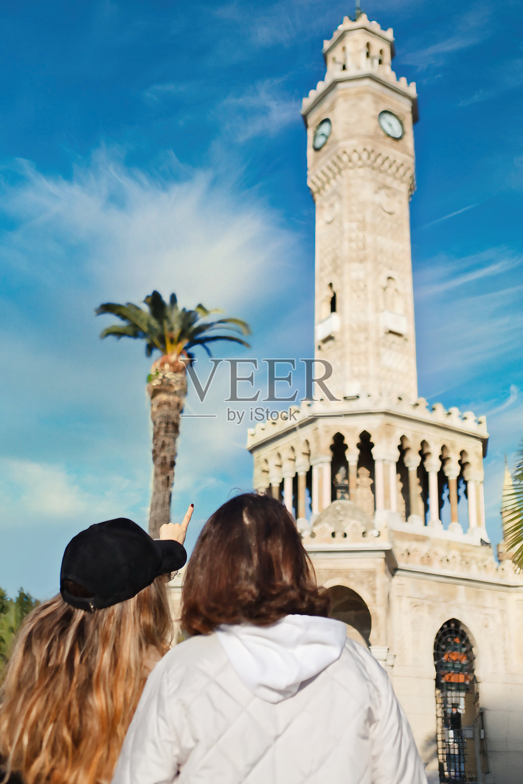 小女孩向她的母亲展示历史悠久的钟楼。照片摄影图片