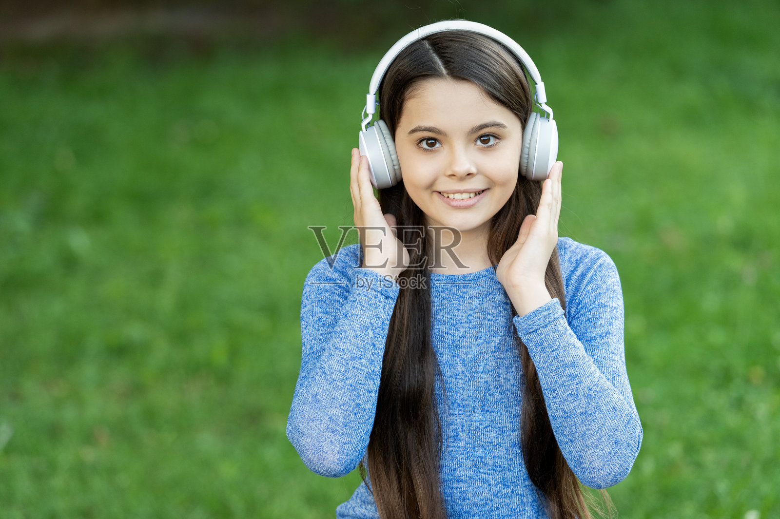 学生的生活方式。听音频。音乐生活方式。青少年女孩在户外佩戴无线耳机听音乐。Z世代生活方式。音乐风格。时尚的青少年女孩听音乐。留白空间。照片摄影图片