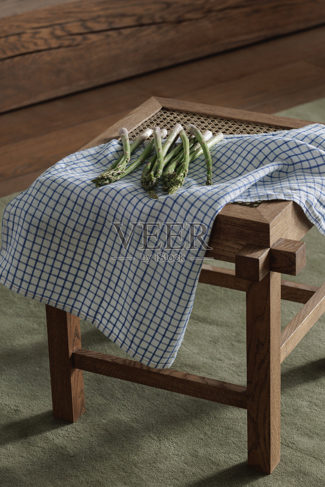 新鲜的芦笋放在藤制凳子上，搭配亚麻茶巾。健康生活方式概念照片摄影图片