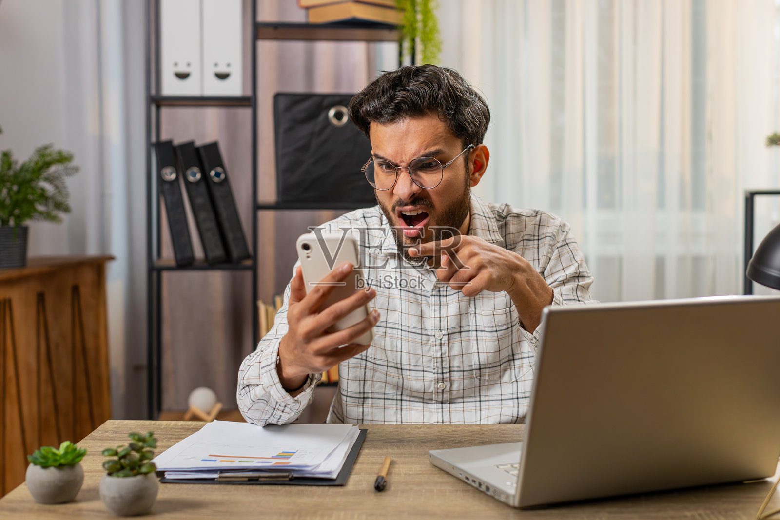 愤怒的生气的商人自由职业者在办公室进行激烈的电话争吵照片摄影图片