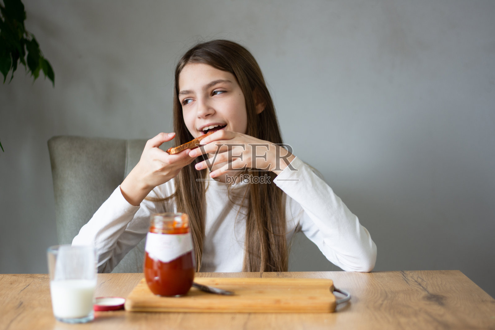 快乐的青少年在吐司上涂果酱照片摄影图片