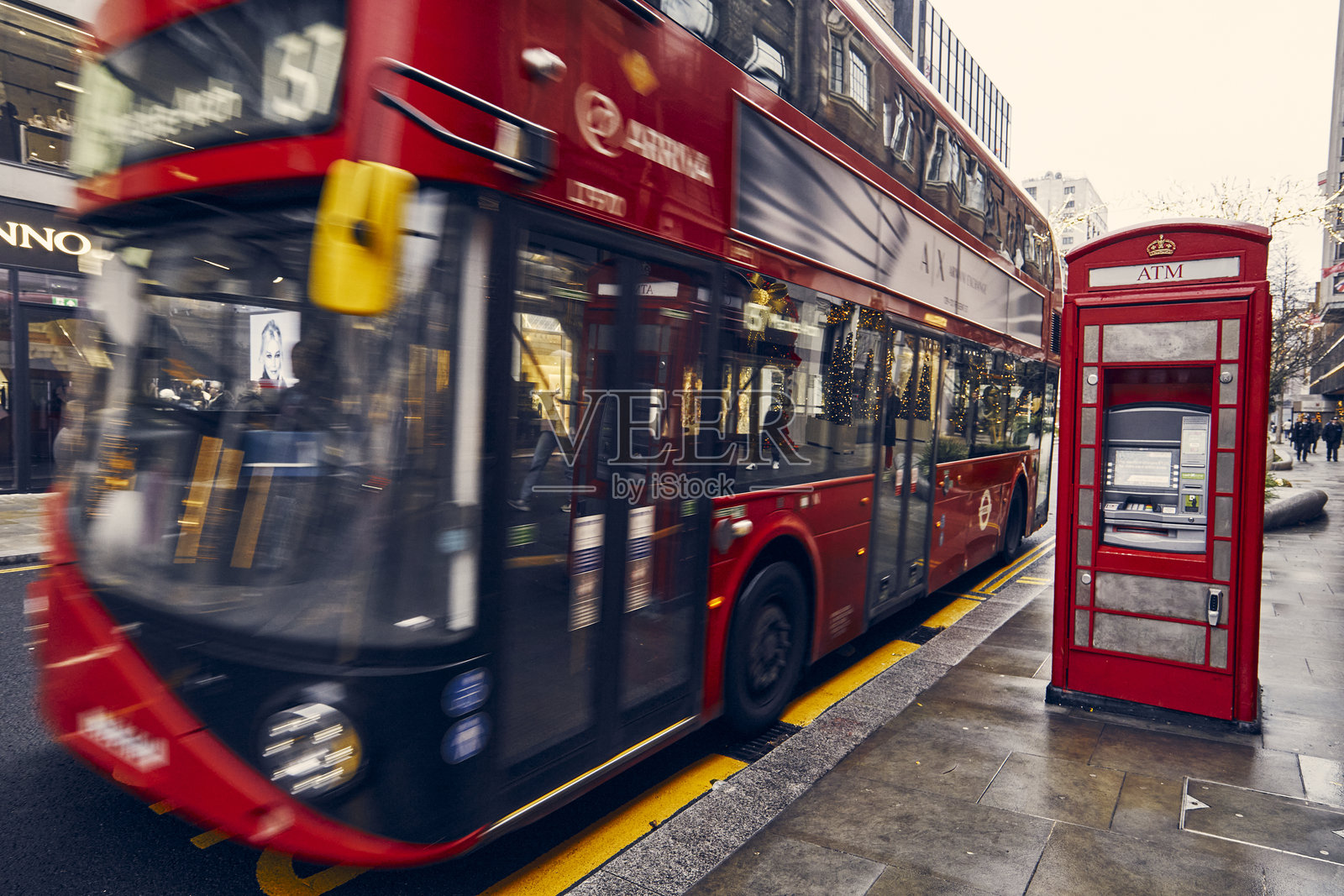 伦敦市著名的红色公交车旁边有一座老式电话亭照片摄影图片