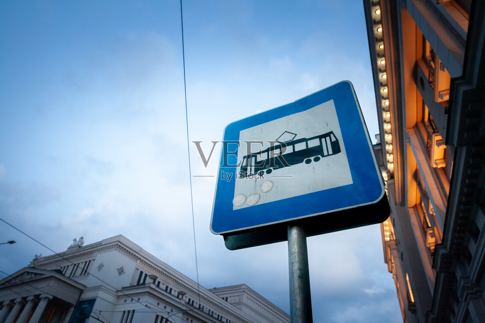 黄昏时分，拉脱维亚里加的一个有轨电车站牌上有选择性的模糊，表明有一个与公共交通线路相连的有轨电车站牌。照片摄影图片