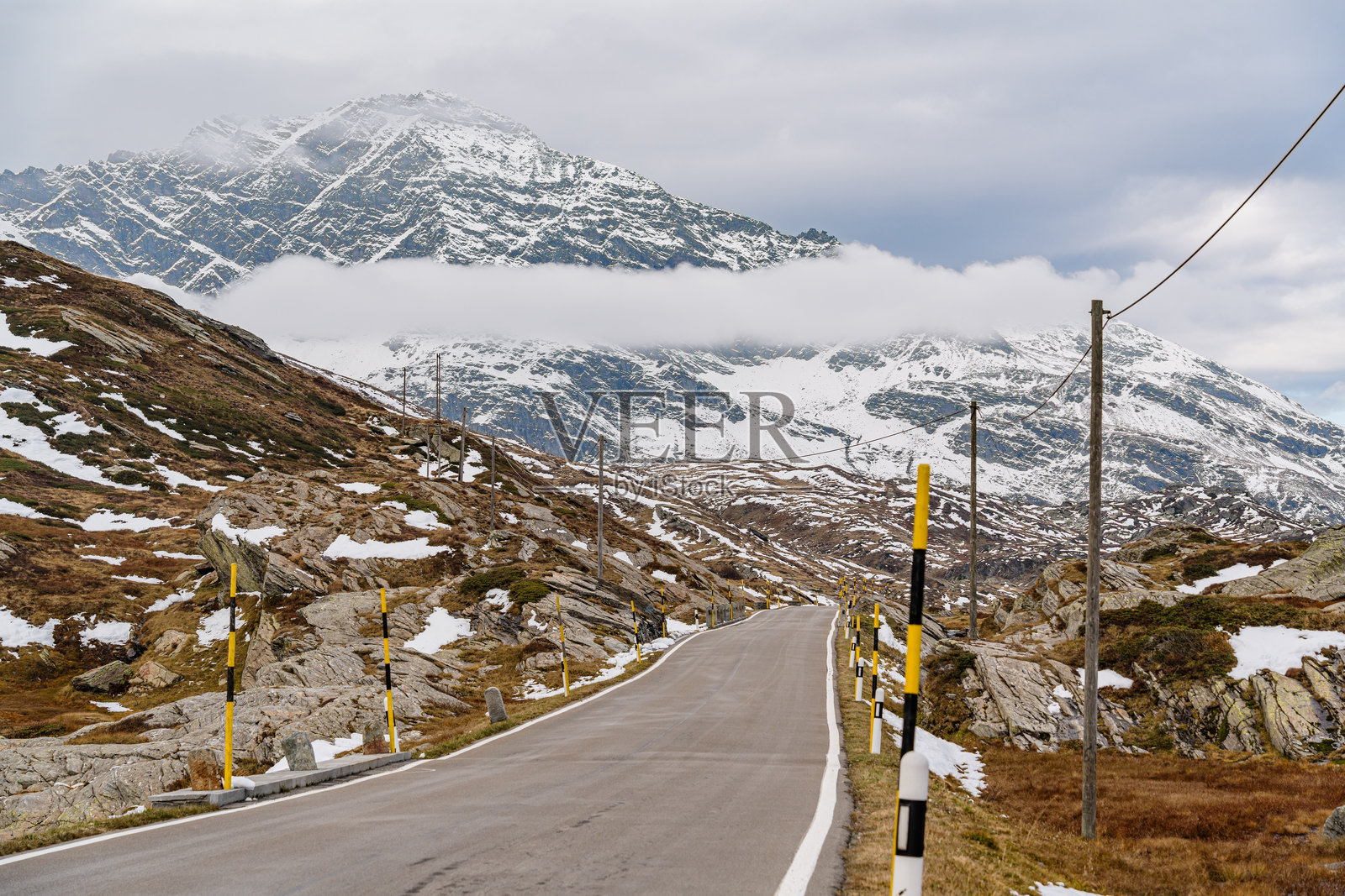 瑞士圣伯纳迪诺山口。路边有一根黄黑相间的标杆。照片摄影图片