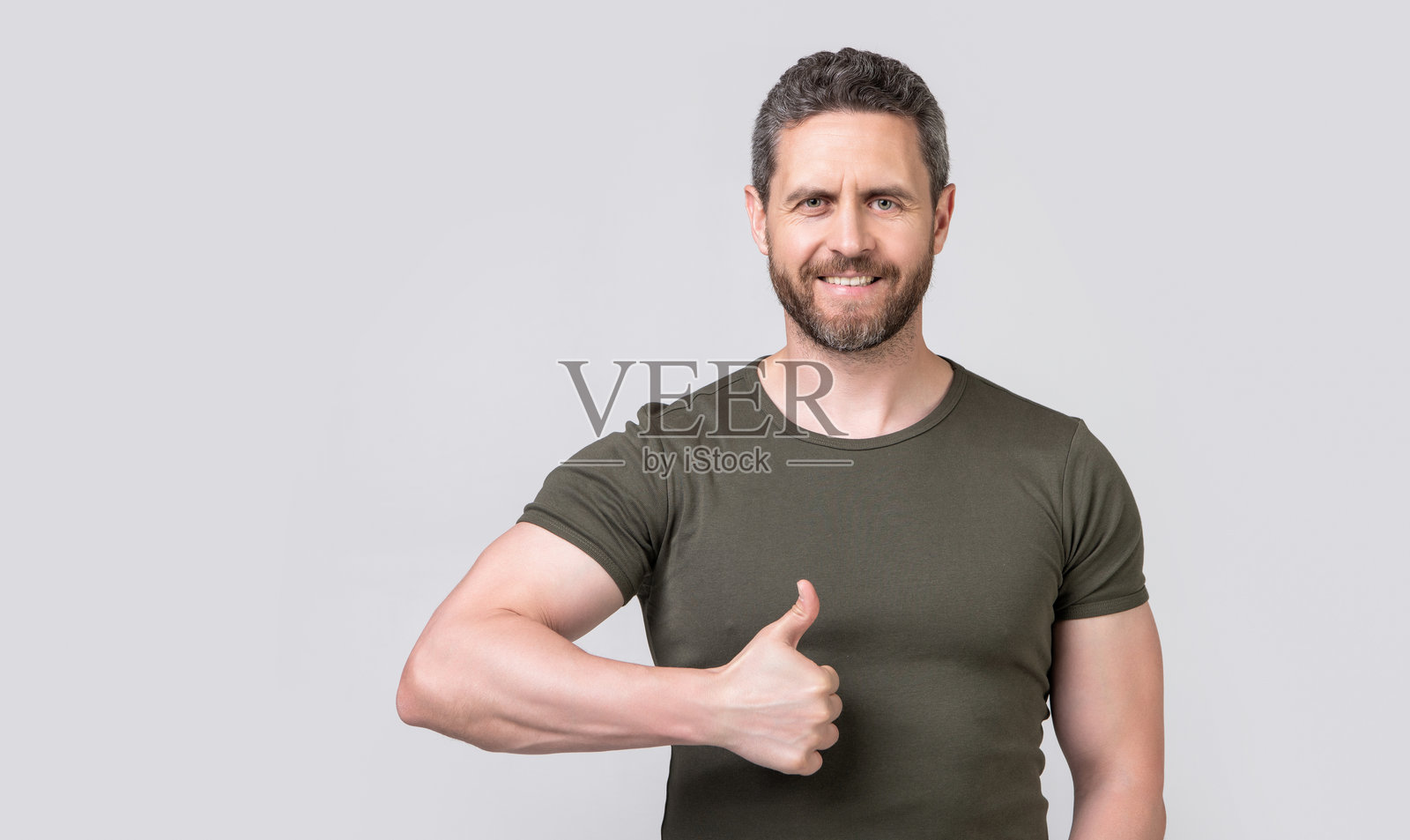 开心的白人男性竖起大拇指表示赞同，穿着T恤。照片摄影图片