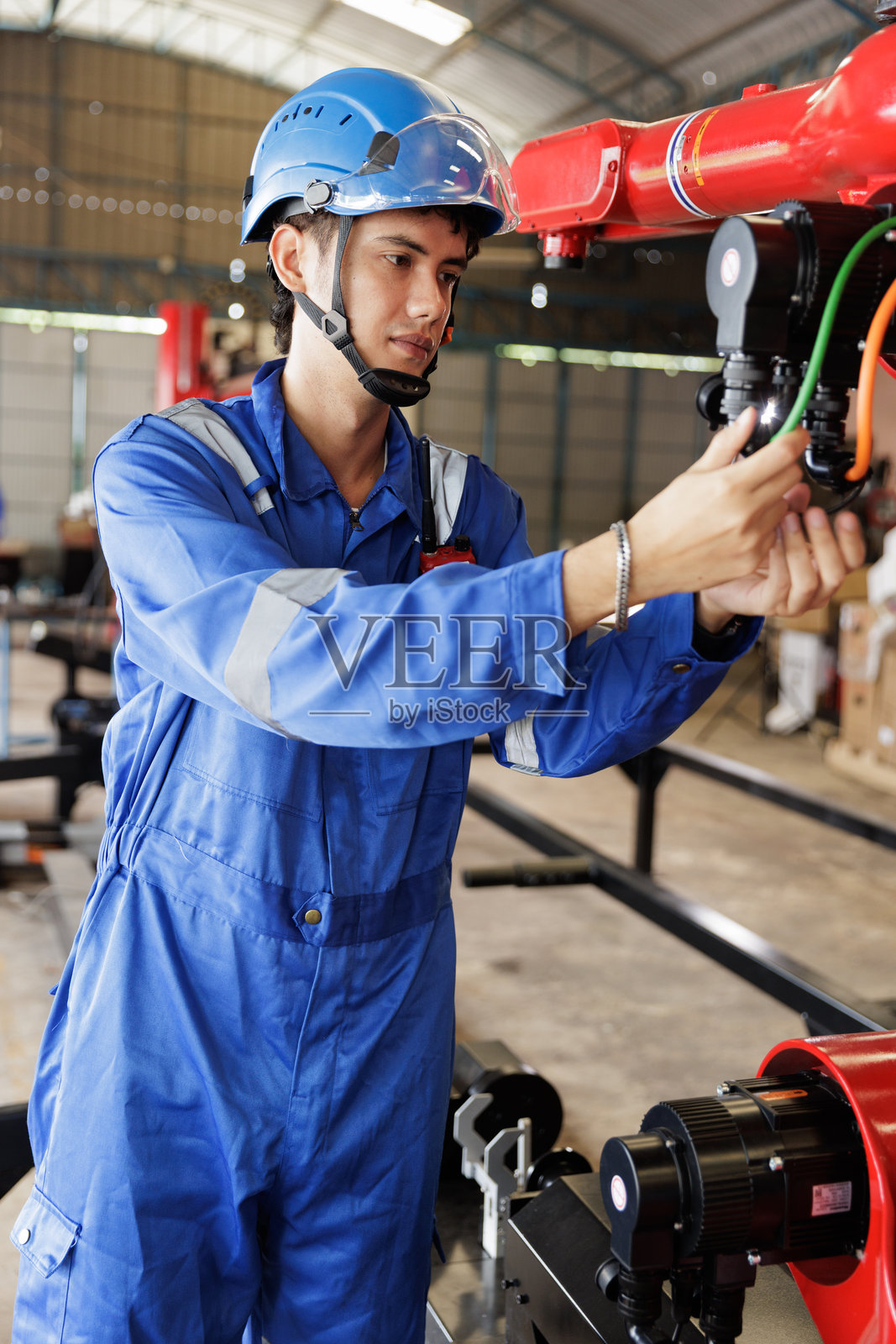 工程师在工业工厂检查机器人手臂照片摄影图片