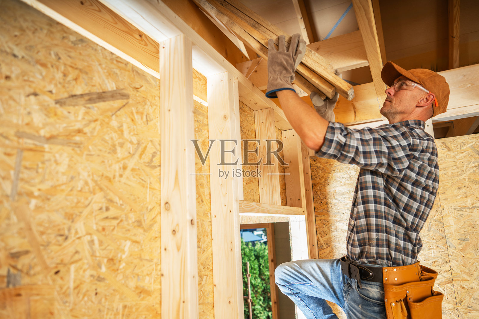 一名木匠在白天的装修中安装部分建造内部的木梁照片摄影图片