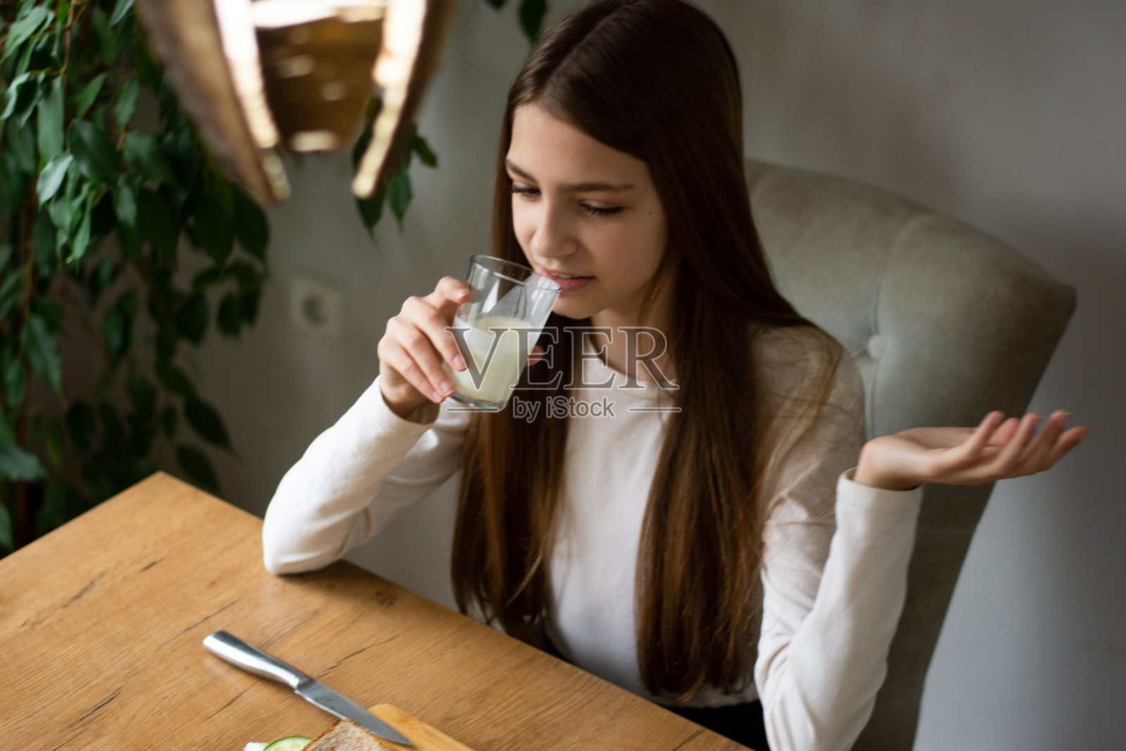 坐在早餐桌前喝牛奶的少女肖像照片摄影图片