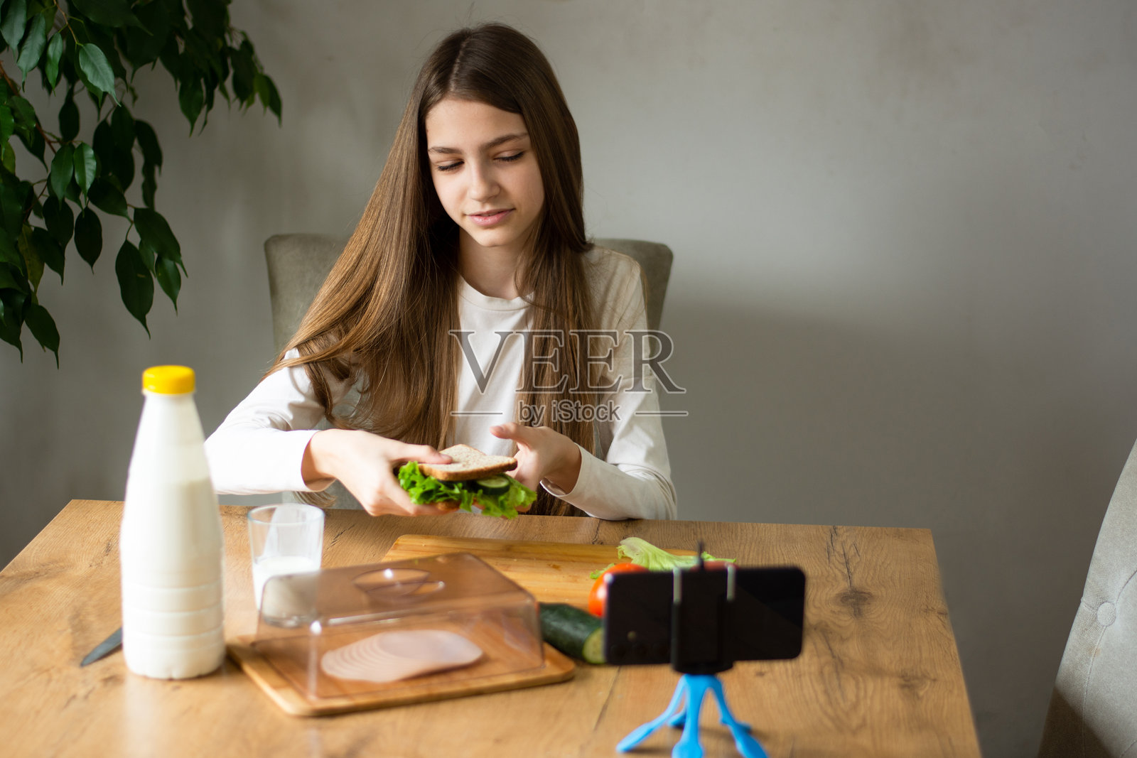 青少年女孩博主用智能手机拍摄视频照片摄影图片