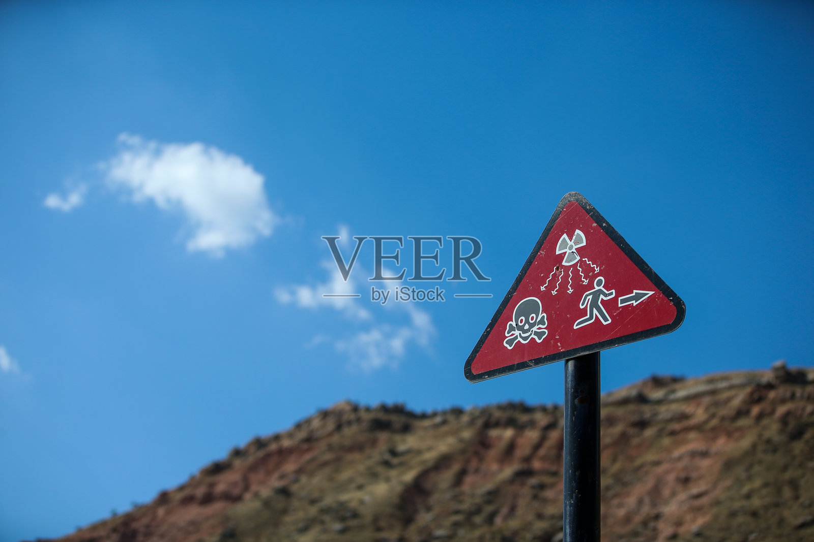 吉尔吉斯斯坦Mailuu-Suu村附近的尾矿堆放场旁的辐射标志。照片摄影图片