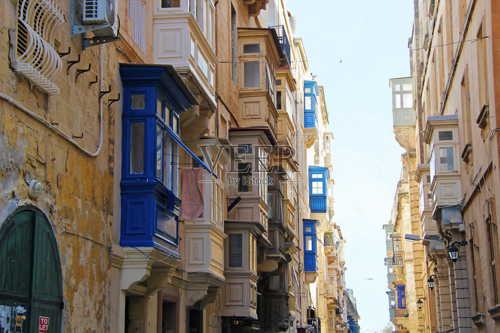 瓦莱塔历史悠久的老城区房屋，蓝色彩色阳台和狭窄街道照片摄影图片