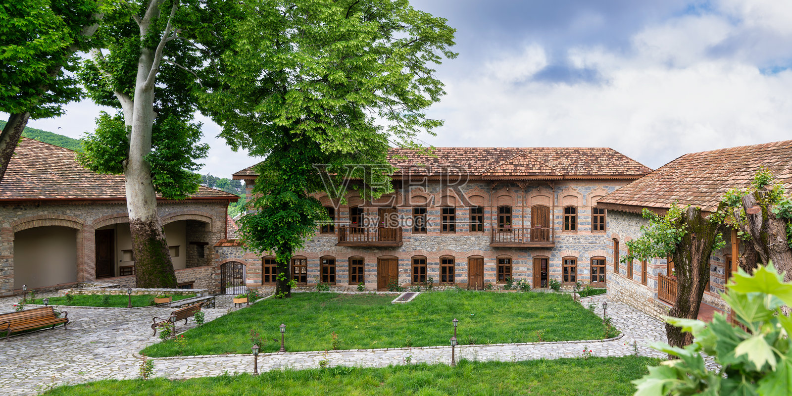 沙基汗清真寺综合体，位于阿塞拜疆沙基，是一座历史悠久的建筑，展示了石墙和木阳台。照片摄影图片