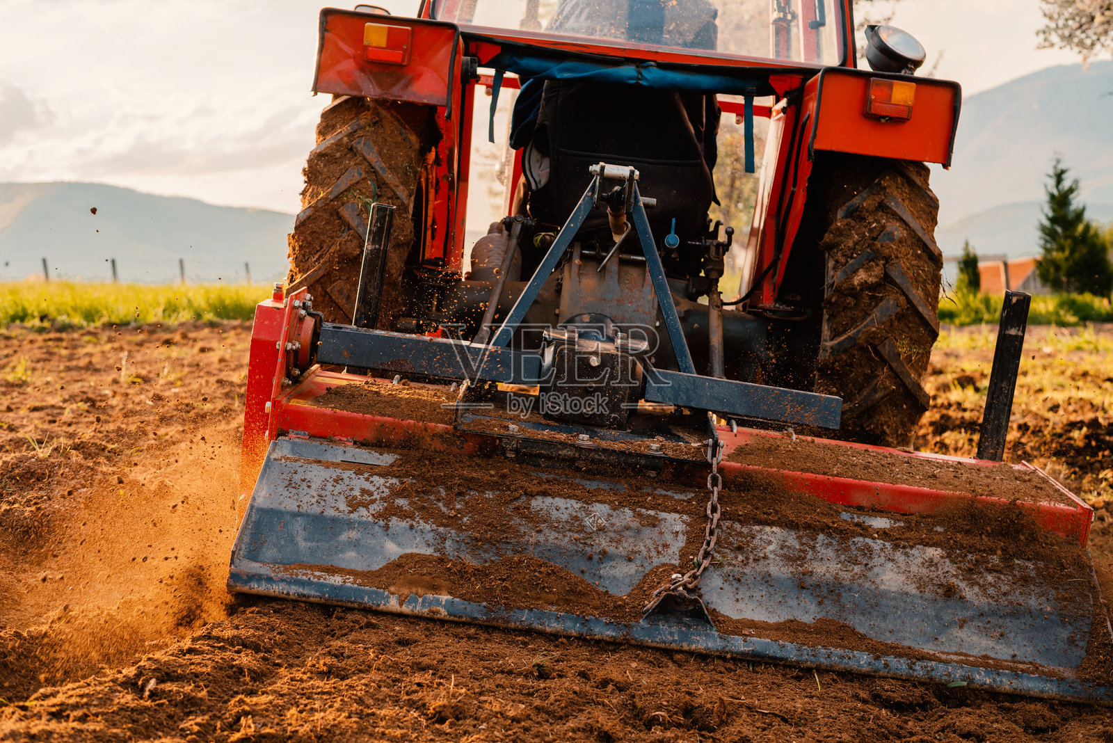 春季农田中拖拉机播种作物。照片摄影图片