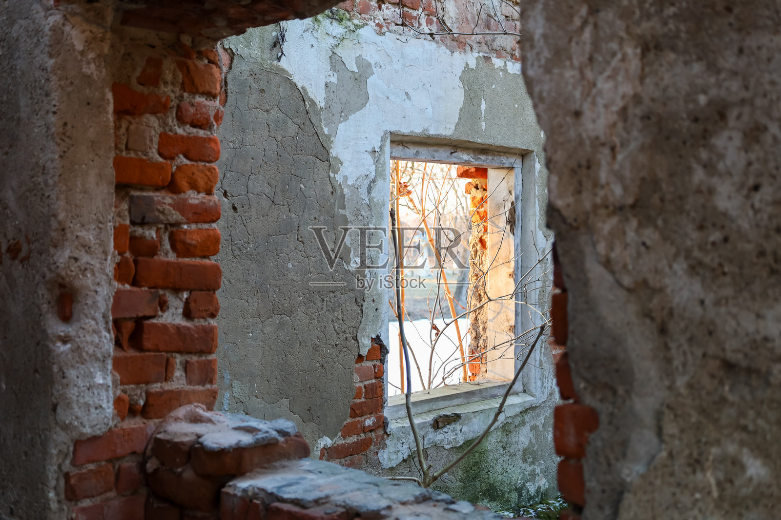 这张照片展示了一座建筑废墟中的窗户。建筑的墙壁部分被毁坏，砖石和残留的灰泥可见。照片摄影图片