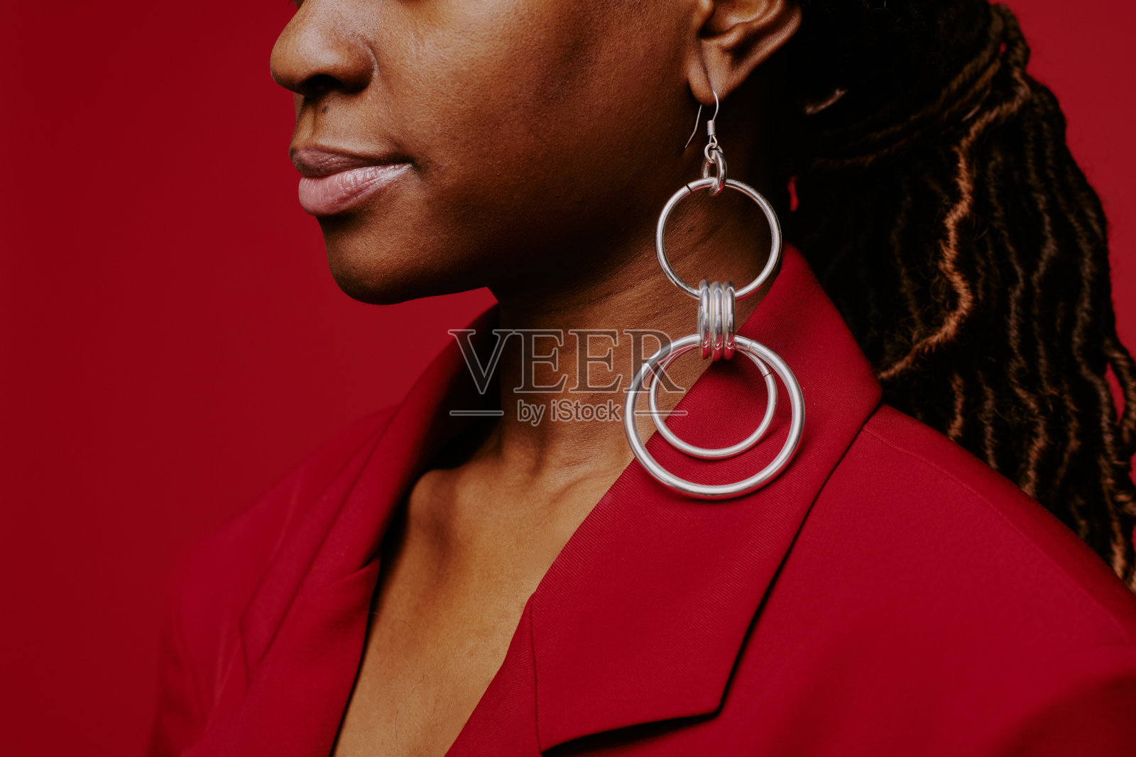 佩戴大圈耳环的红色背景照片摄影图片