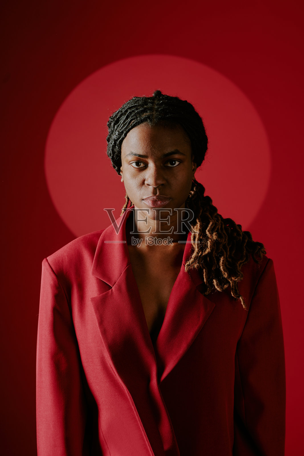 穿着红色西装的女性肖像，背景为红色照片摄影图片