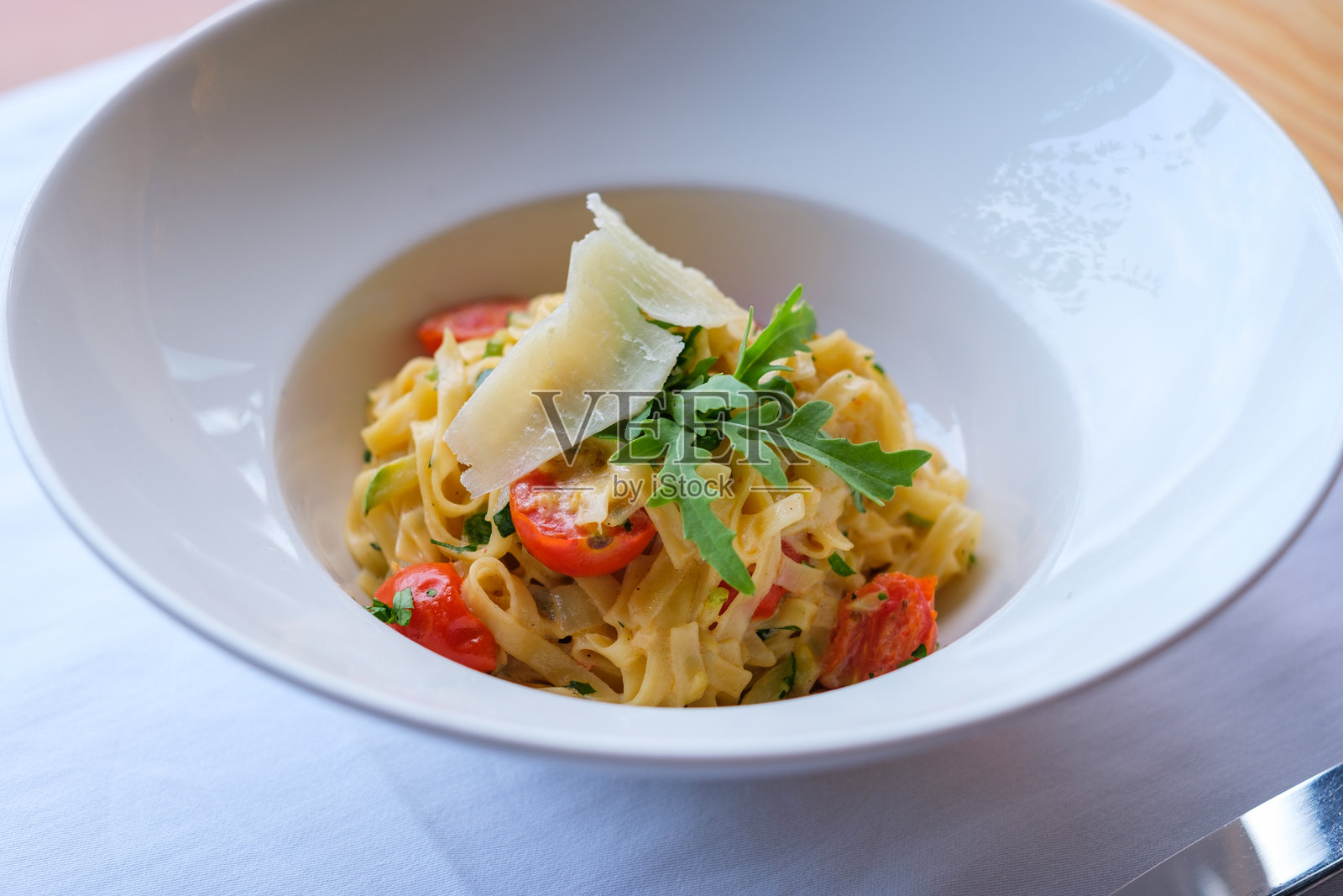 一盘意大利面配樱桃番茄、西葫芦和帕尔马干酪照片摄影图片