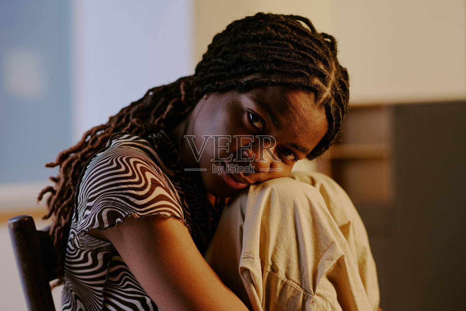 沉思的非裔美国女性坐在椅子上照片摄影图片