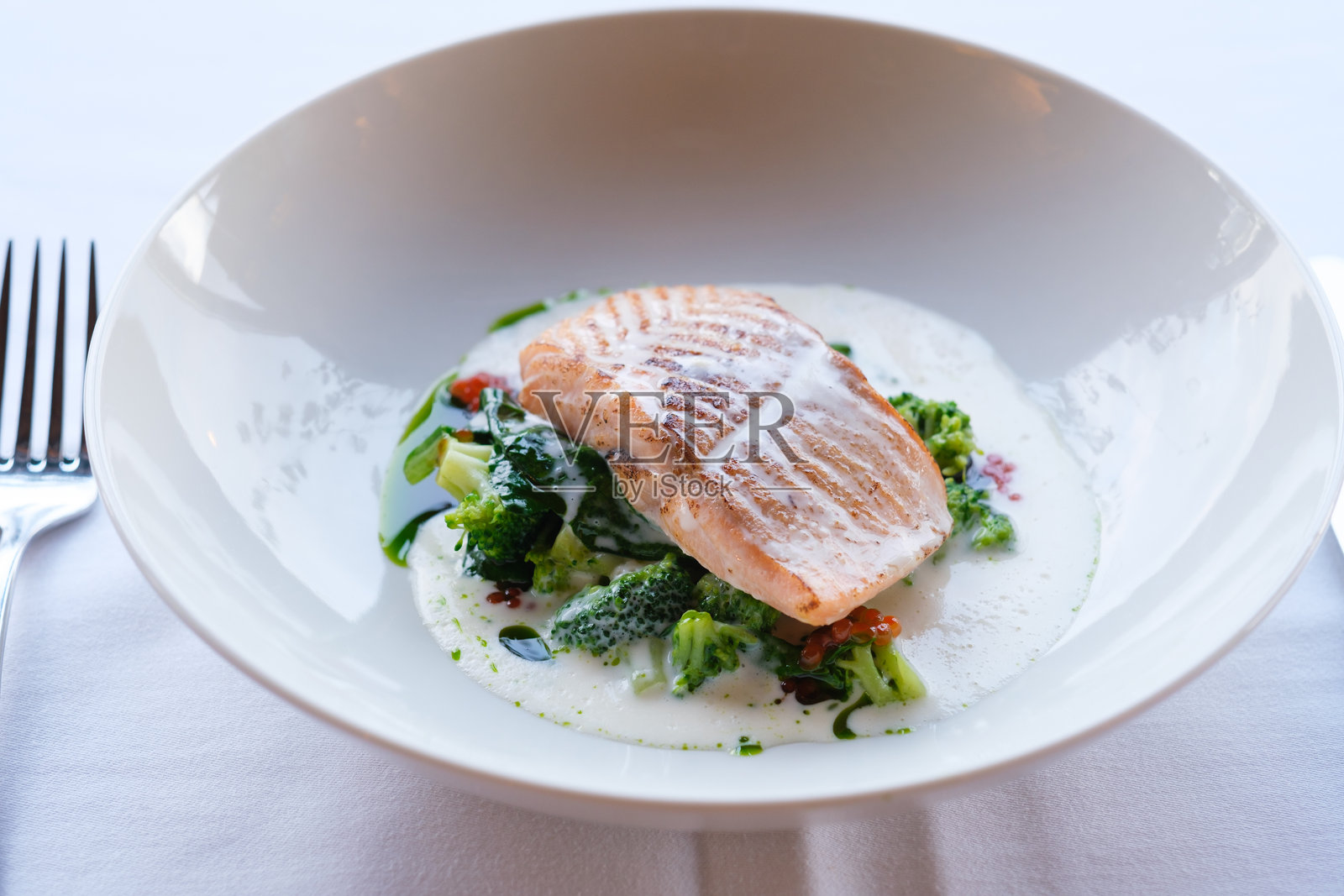 煎鱼片配炒西兰花和奶油酱照片摄影图片