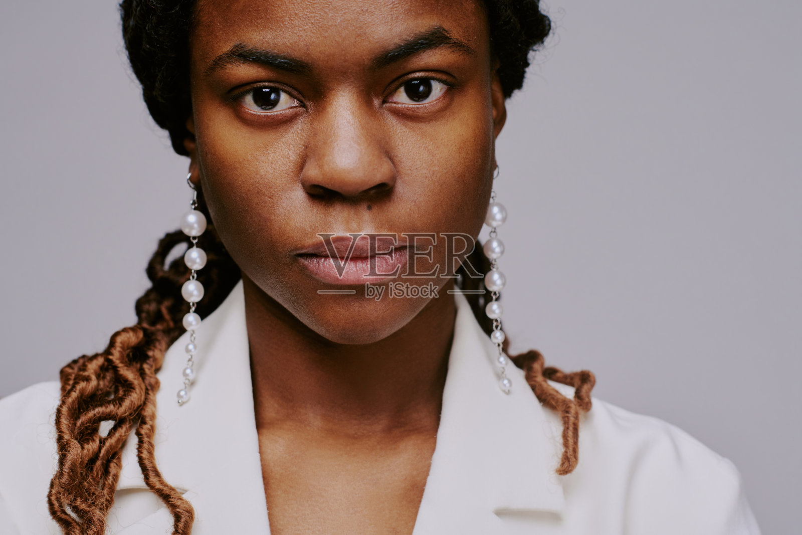 穿着白色西装外套和珍珠耳环的女性肖像照片摄影图片