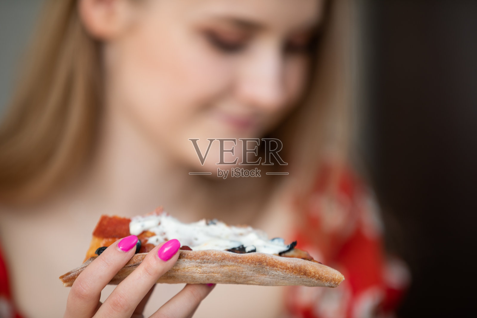 一只手握着一片披萨的特写镜头。照片摄影图片