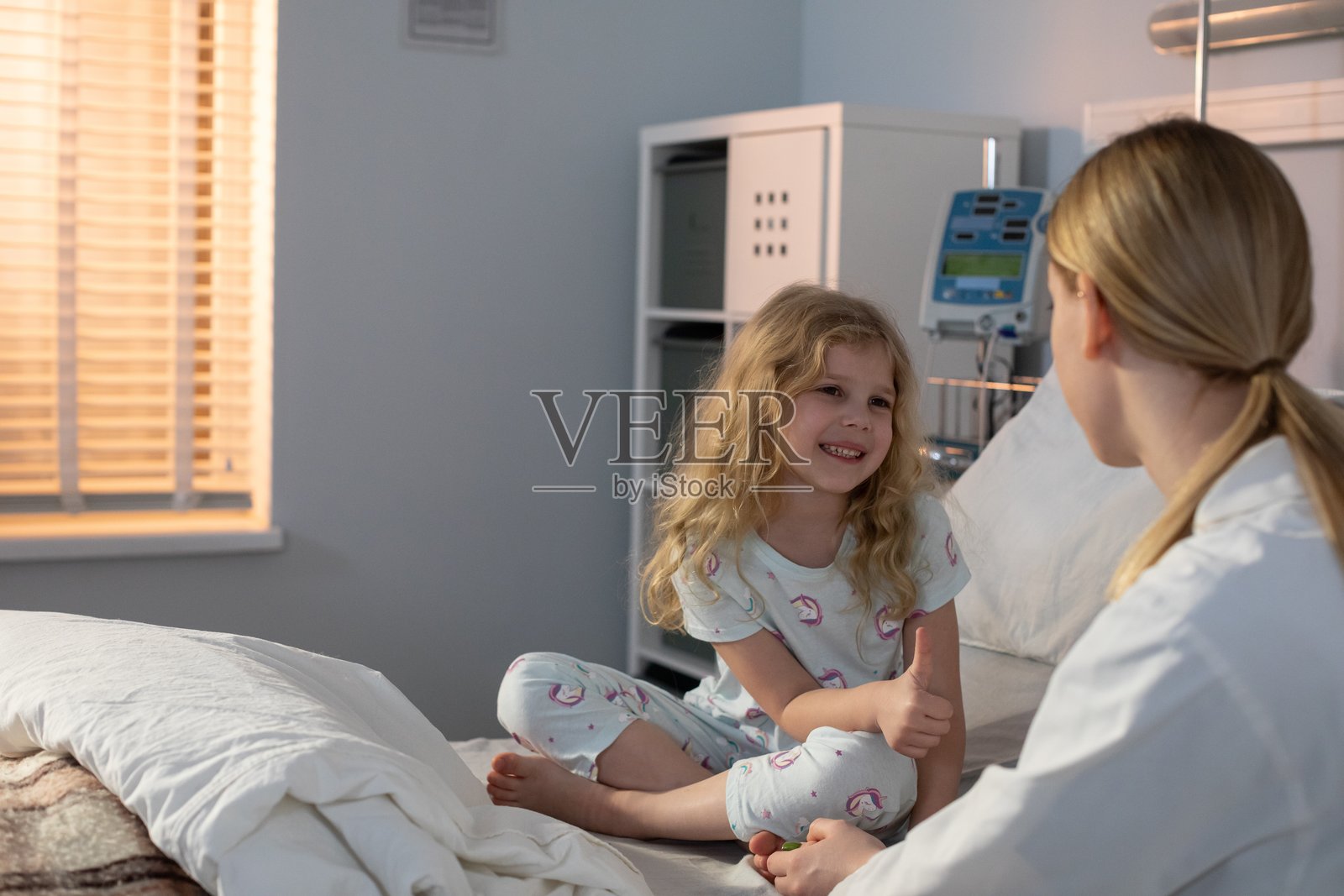 医院病床上的孩子与护理人员，情感温馨的安慰与治愈时刻照片摄影图片