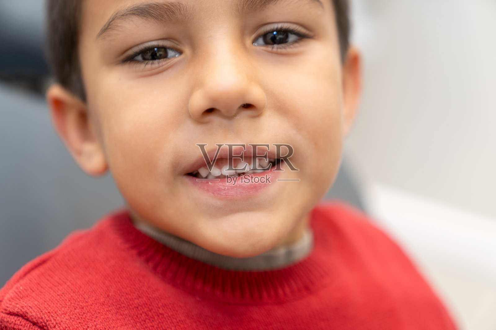 微笑的学龄前男孩露出牙齿的肖像照片摄影图片