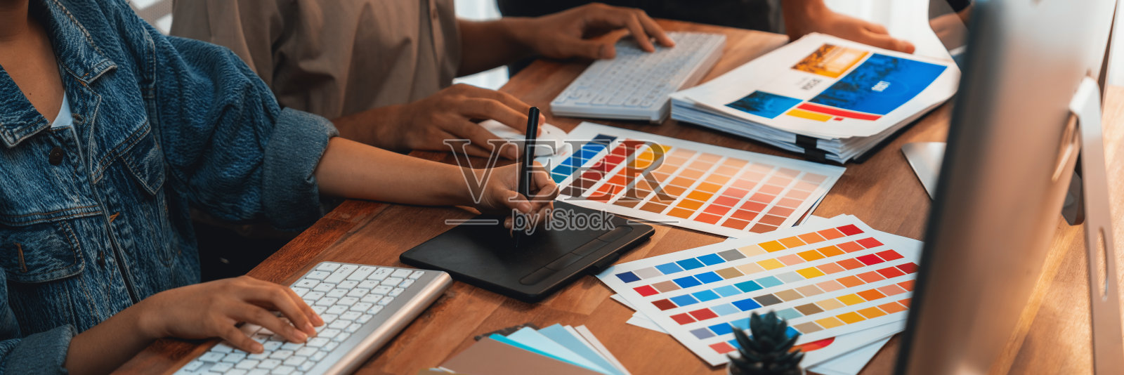 平面设计师使用数位笔在笔记本电脑上工作。照片摄影图片