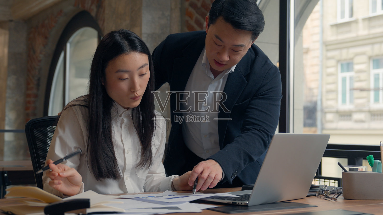 两位亚洲女商人和男商人在一起合作，分析文件，共同进行管理工作。照片摄影图片