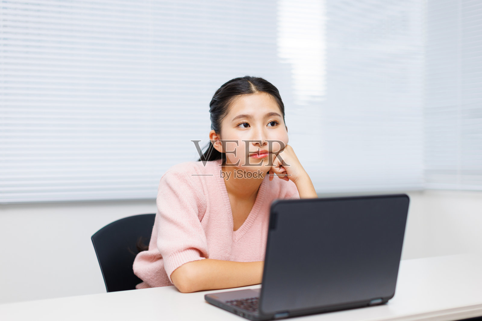 亚洲少女在使用笔记本电脑时沉思照片摄影图片