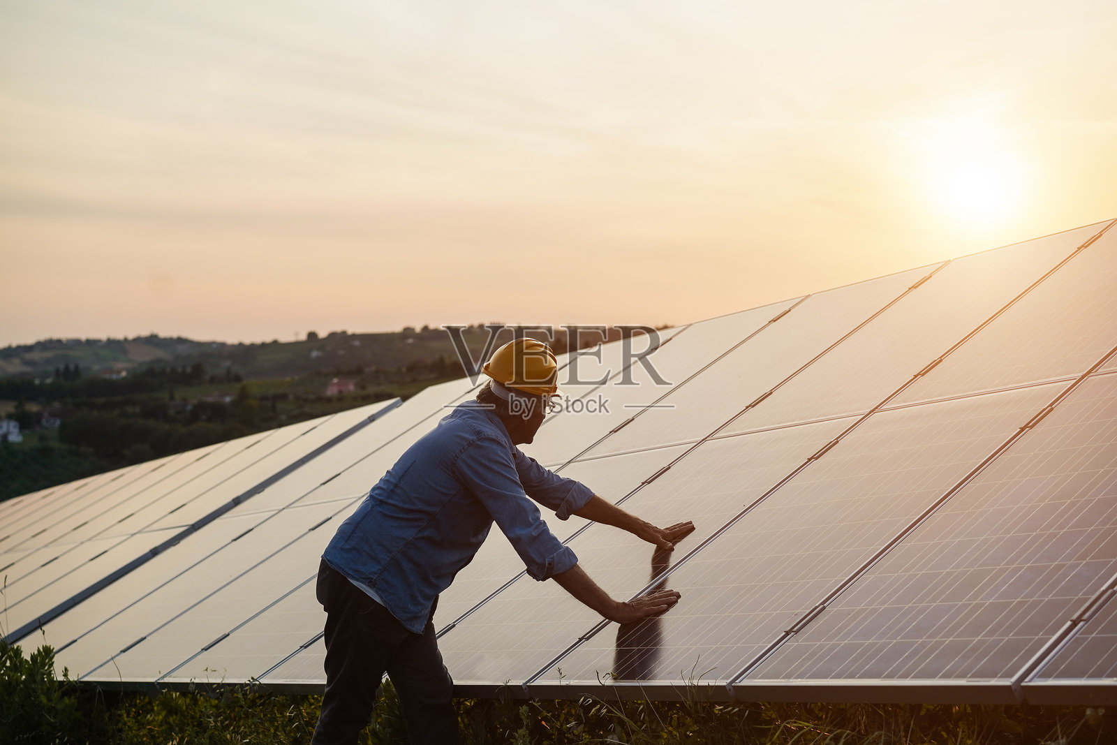 在太阳能电池板站工作的男人 - 可再生绿色能源概念 - 重点关注面部照片摄影图片