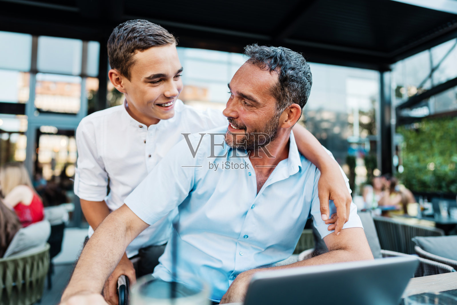 父亲和儿子在现代咖啡馆或餐厅里照片摄影图片