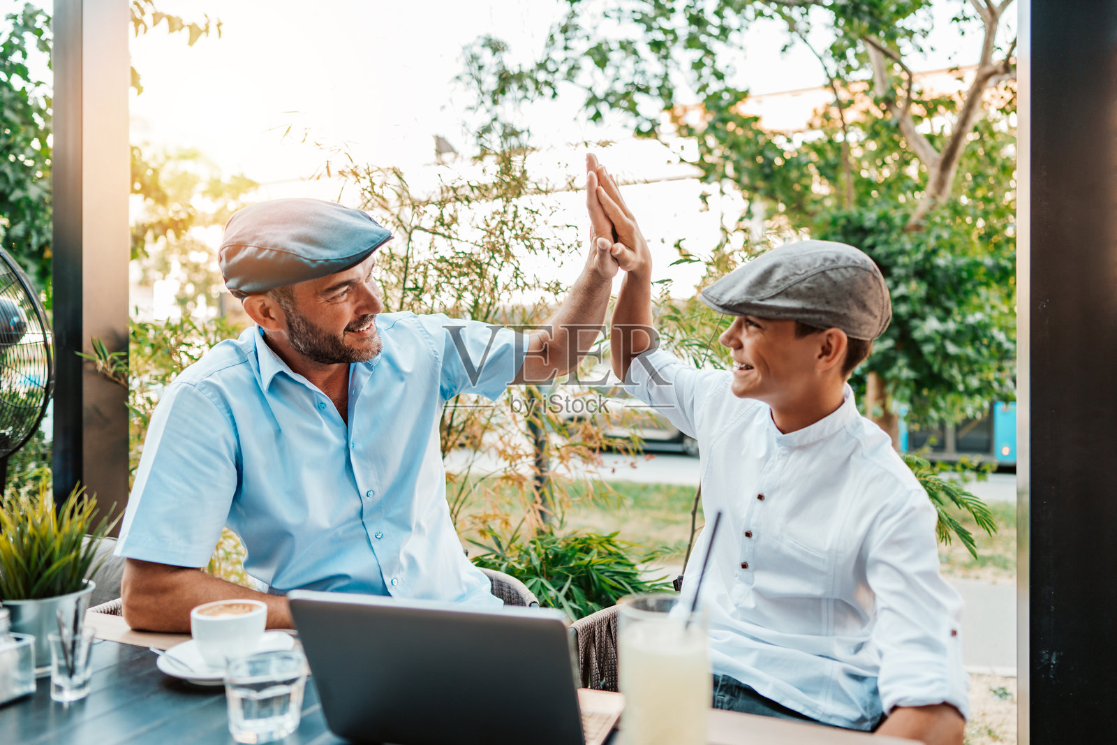 父亲和儿子在现代咖啡馆或餐厅里照片摄影图片