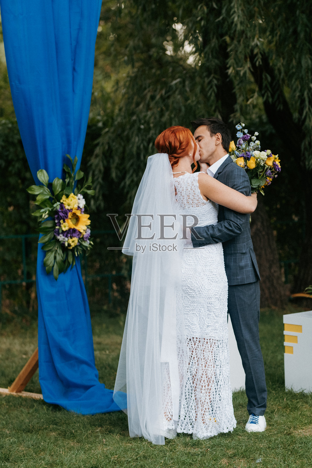 一对年轻情侣在绿草地上的婚礼仪式照片摄影图片