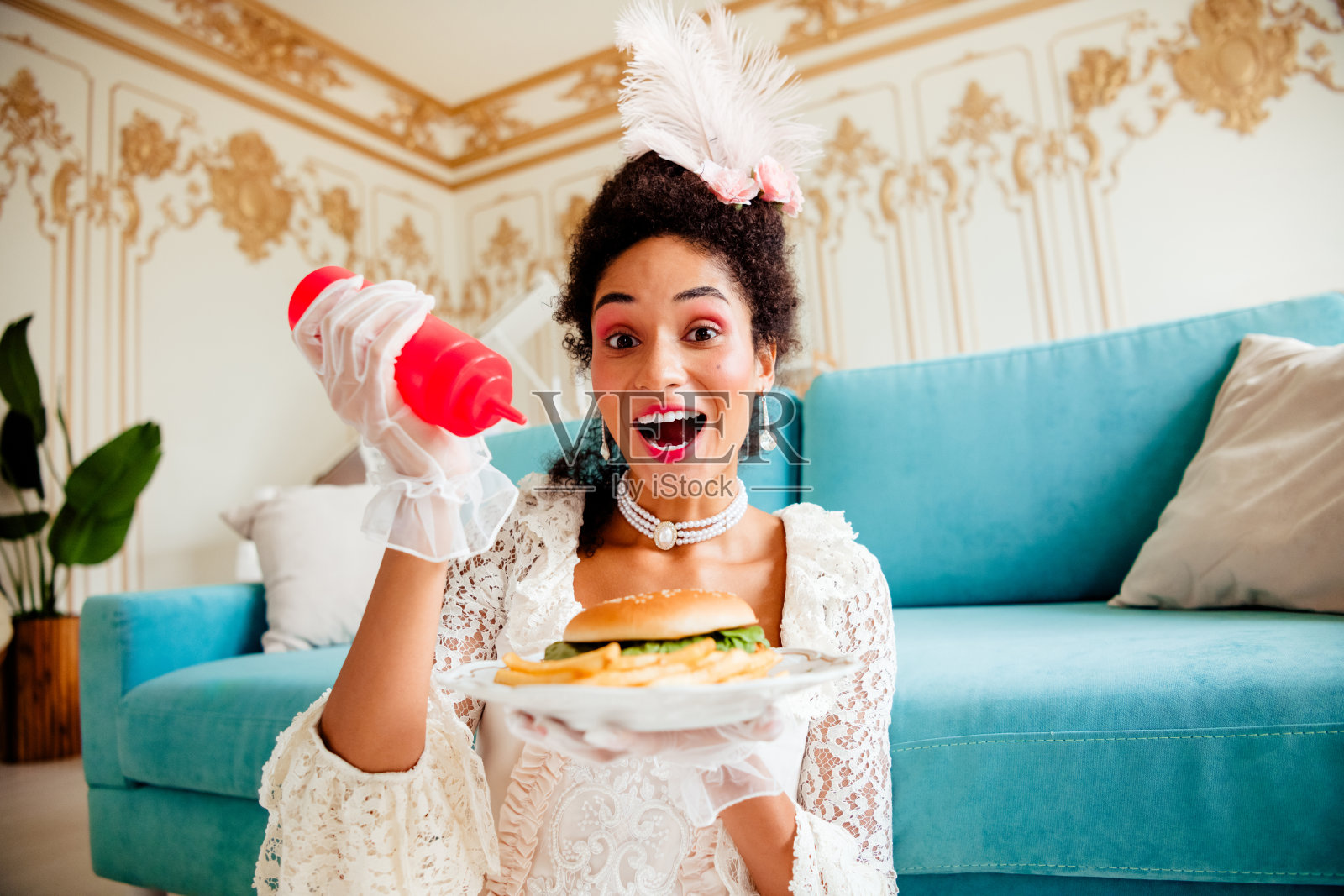 优雅的年轻女士穿着复古裙子，在巴洛克风格的室内拿着现代餐点照片摄影图片