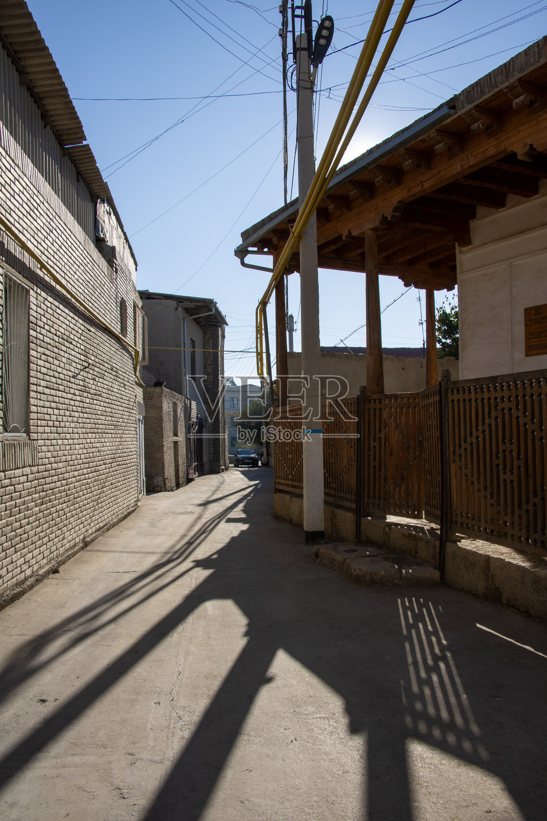 乌兹别克斯坦布哈拉 - 2024年10月15日：狭窄的街道，旁边是霍贾·布尔戈尔清真寺和房屋照片摄影图片