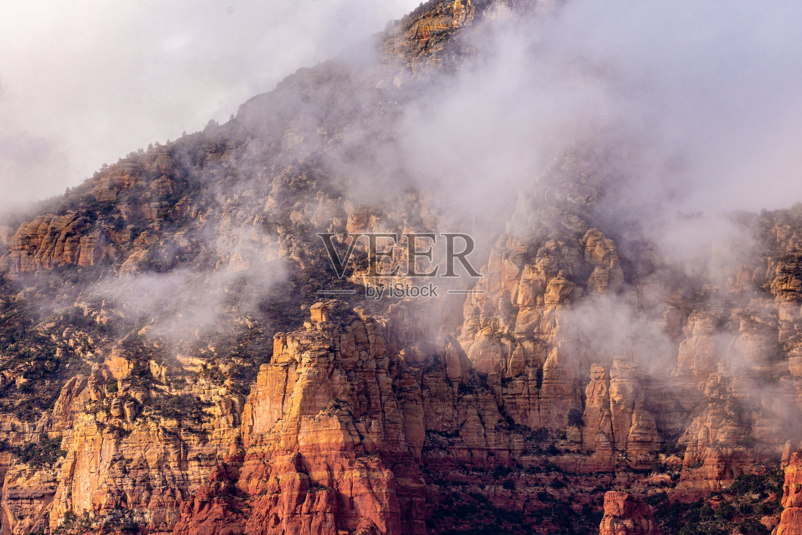 亚利桑那州塞多纳附近红岩尖峰的低云傍晚。照片摄影图片