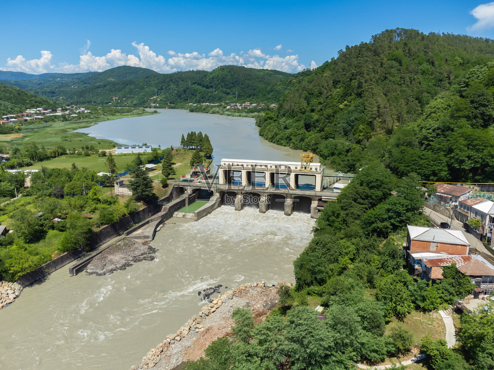 在格鲁吉亚库塔伊西的里昂斯卡亚水电站，阳光明媚的日子里，山脉环绕下的无人机视角照片摄影图片