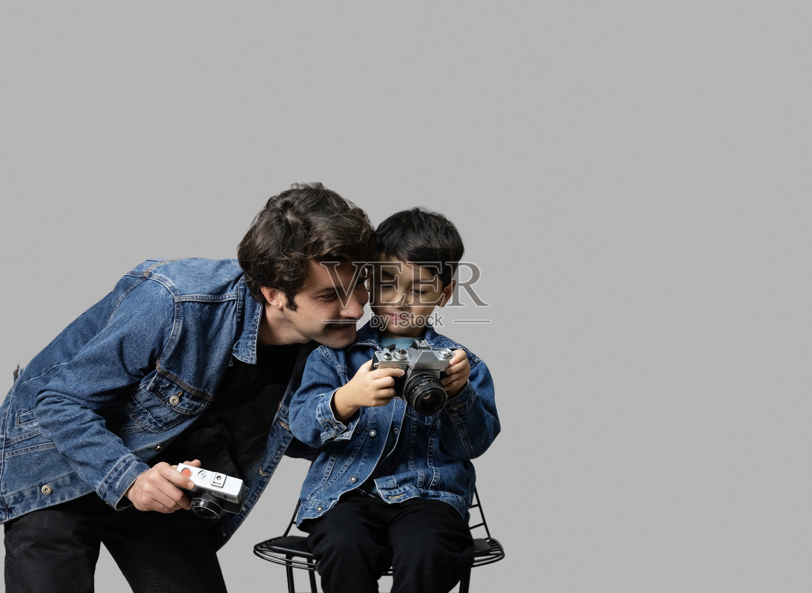 父亲和儿子穿着牛仔夹克在摄影棚拍照照片摄影图片