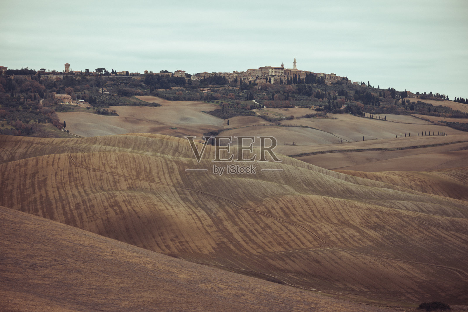 托斯卡纳乡村的美丽风景，山顶上有一排柏树。照片摄影图片