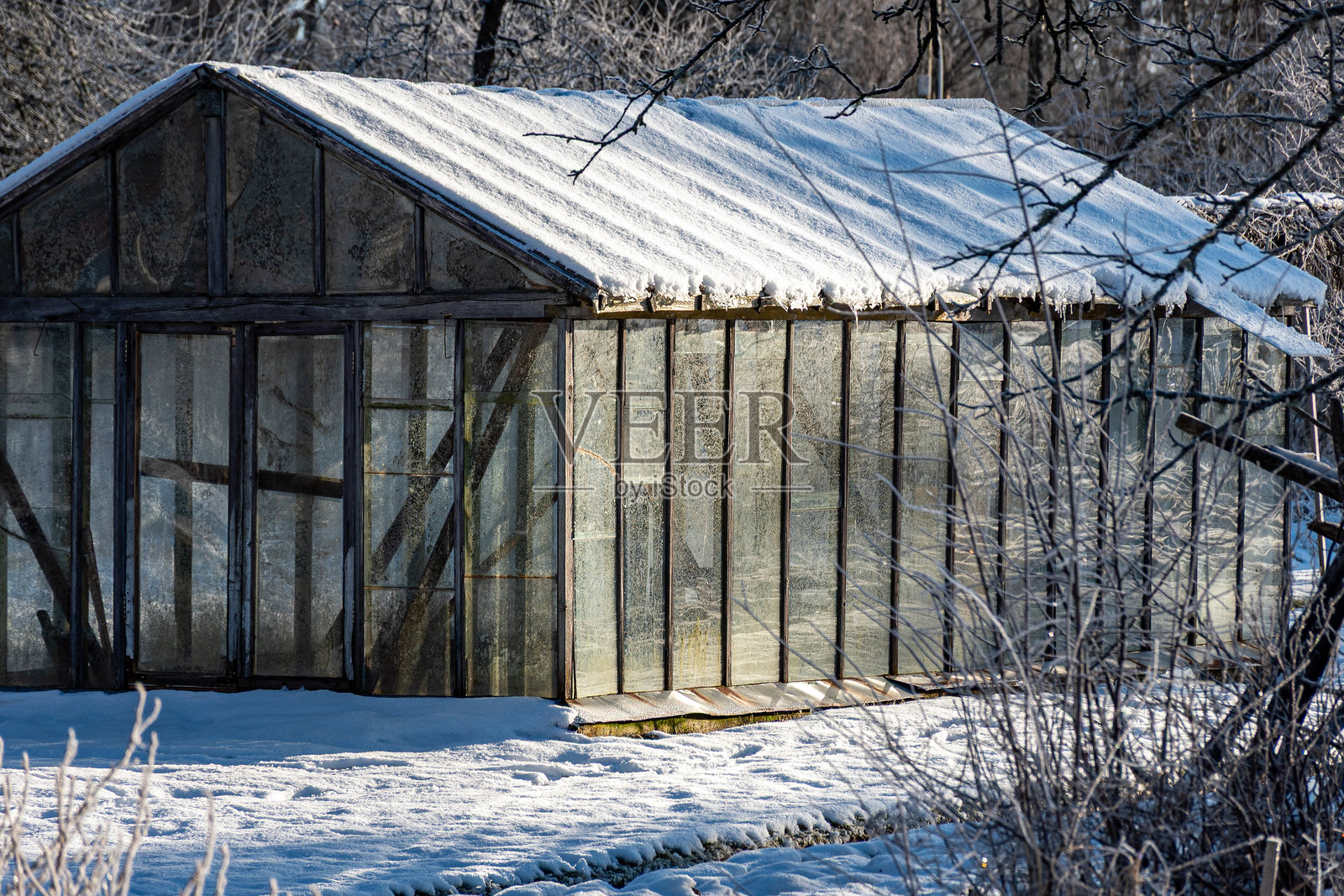 美妙的冬日，树木和草地覆盖着霜，花园里的温室。照片摄影图片