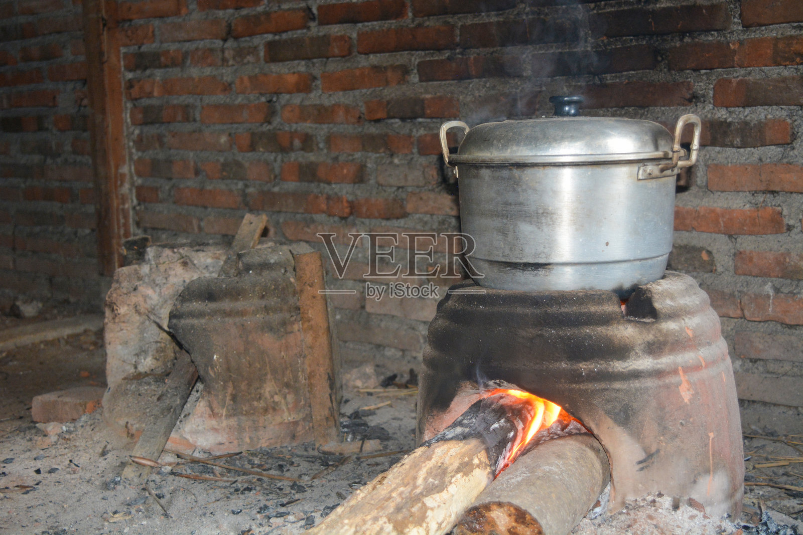 传统的烹饪，使用泥土制成的炉灶和正在煮水的火锅照片摄影图片