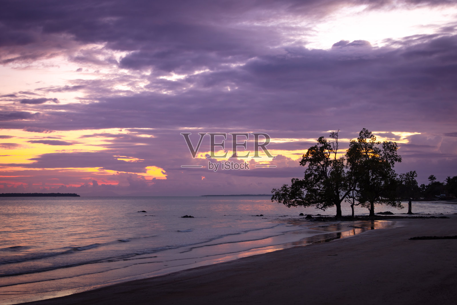 热带海滩上的夕阳西下。照片摄影图片