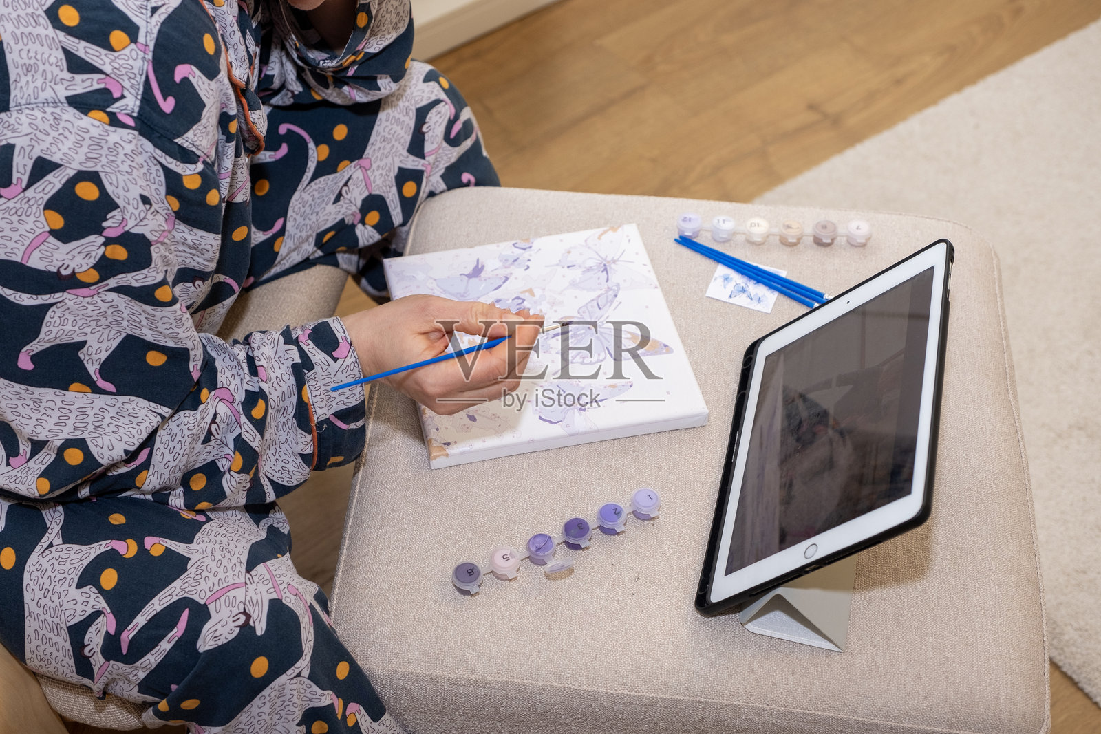 白人女性正在用丙烯颜料绘画。特写镜头展示女性手握画笔。照片摄影图片