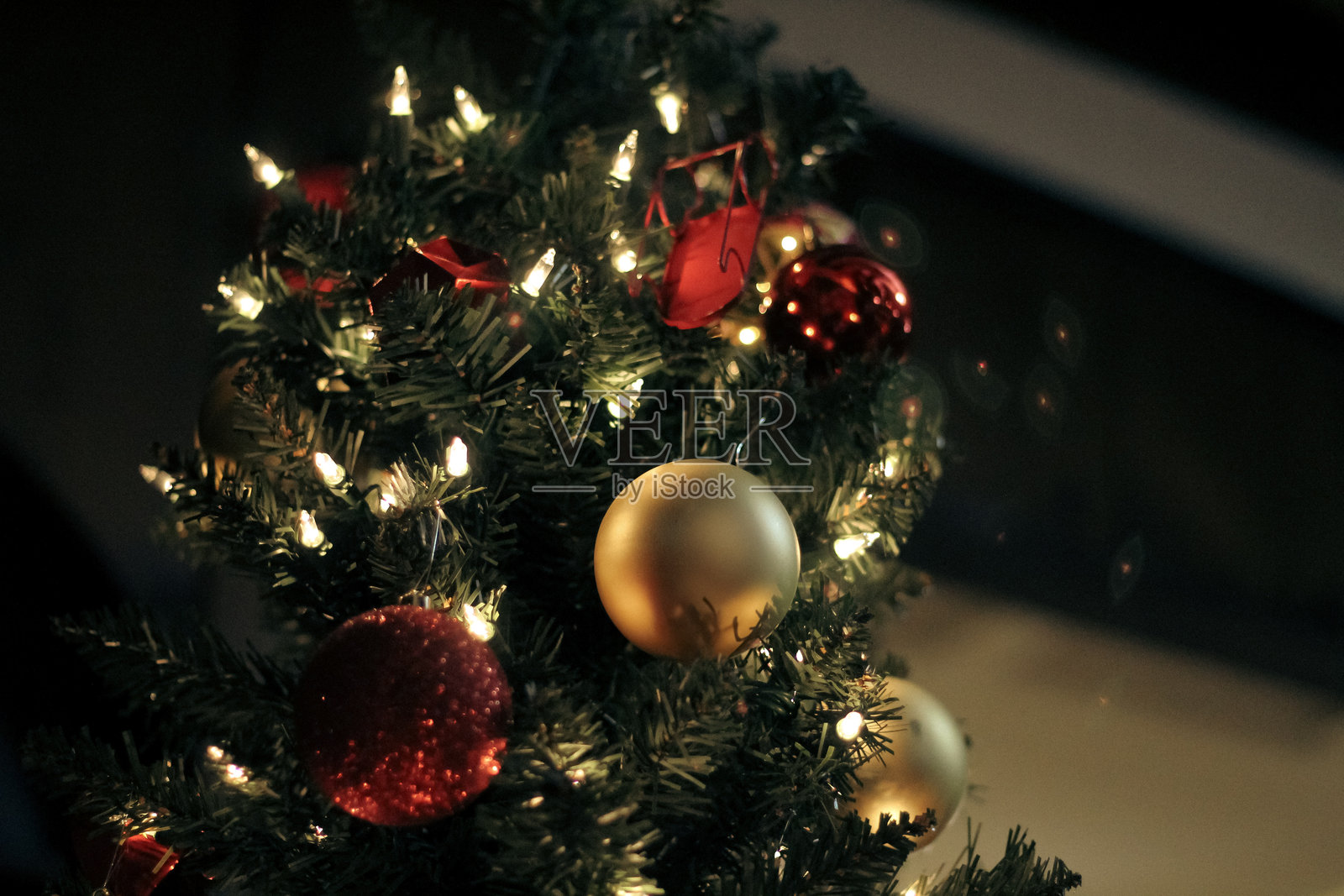 传统圣诞树，装饰有灯光和反射饰品，金色散景效果背景特写摄影照片摄影图片