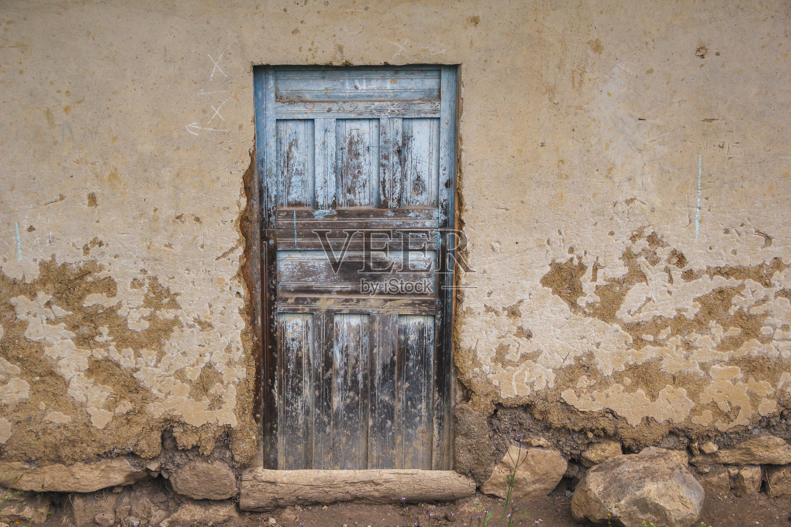 一扇陈旧的木门，带有褪色的油漆痕迹和生锈的锁。照片摄影图片