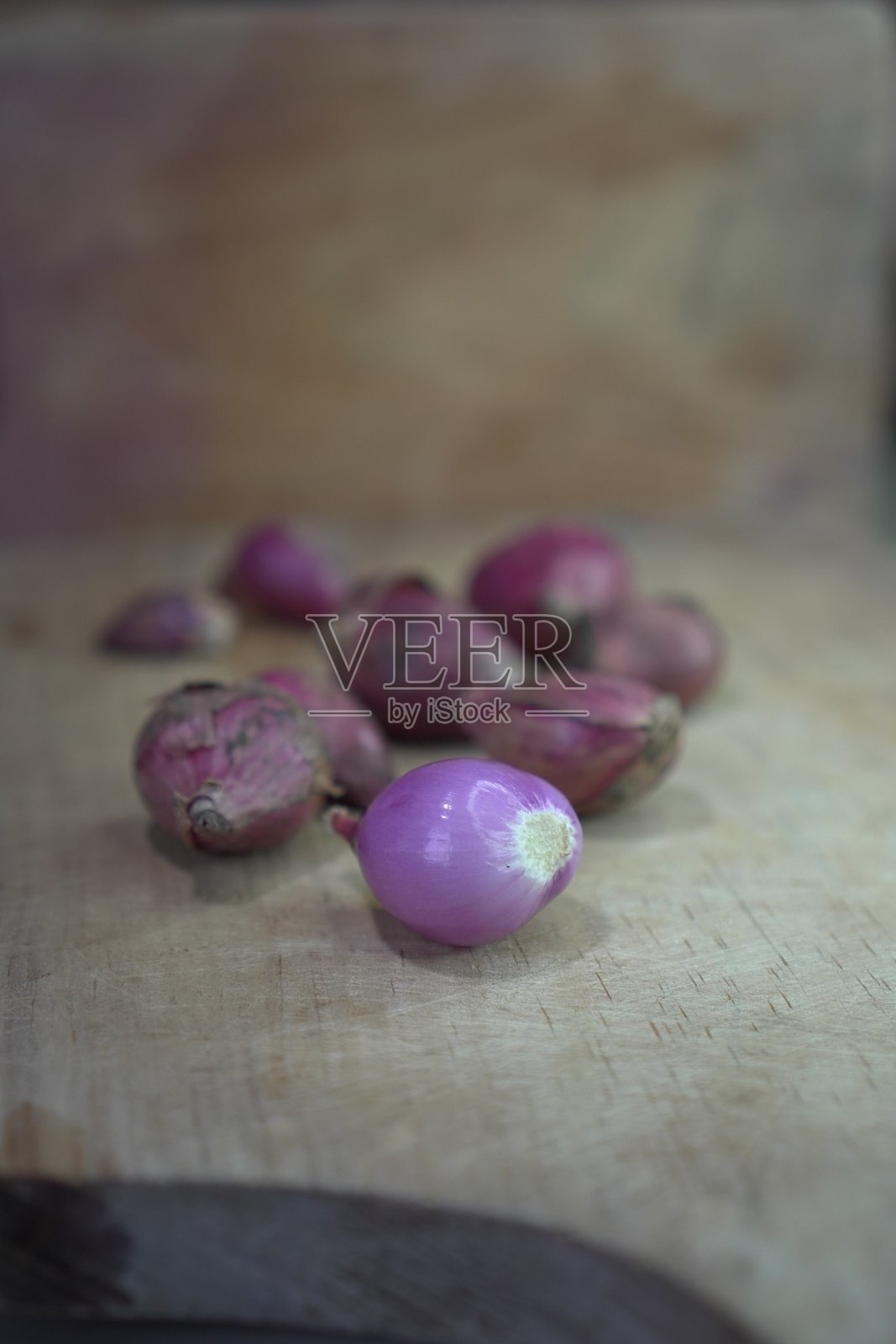 一堆红洋葱放在磨损的木砧板上照片摄影图片