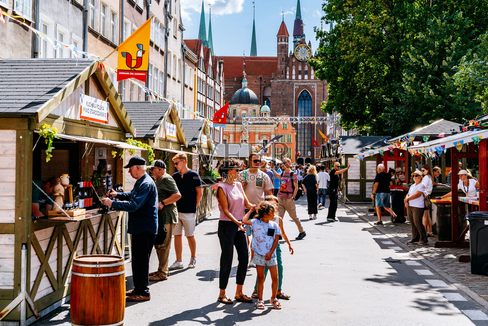 格但斯克老城区街头节日的市场摊位和游客，背景是圣玛丽教堂。照片摄影图片