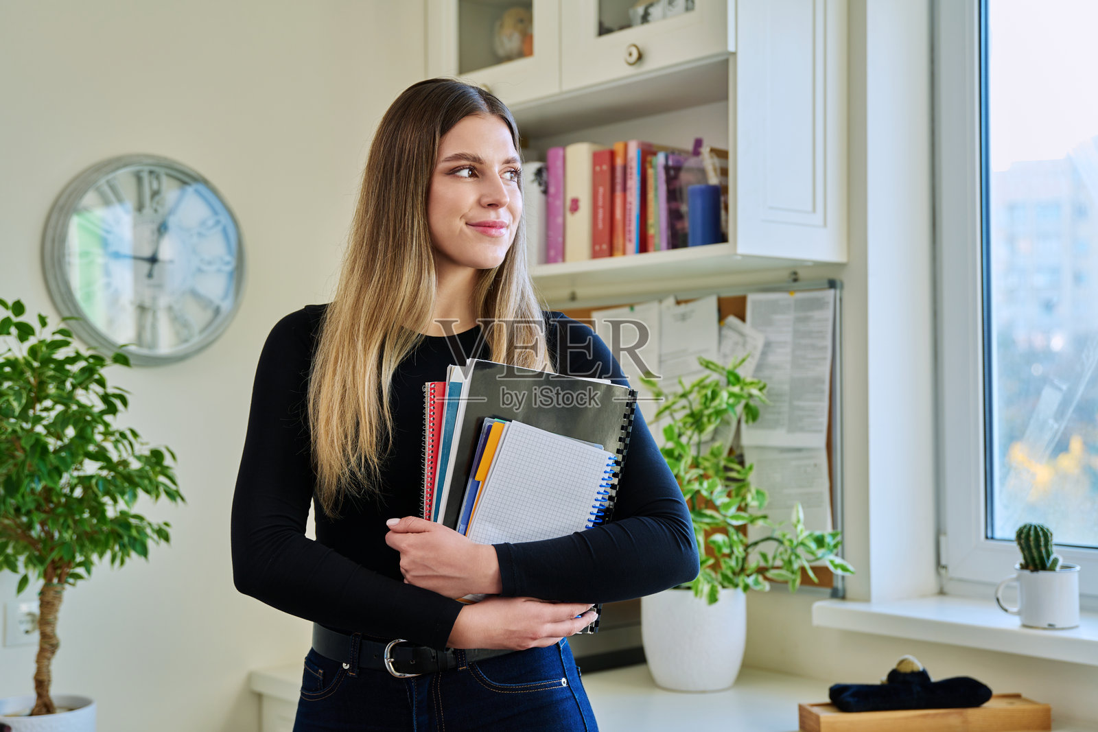 大学女学生在家中手持教科书和笔记本的肖像照片摄影图片