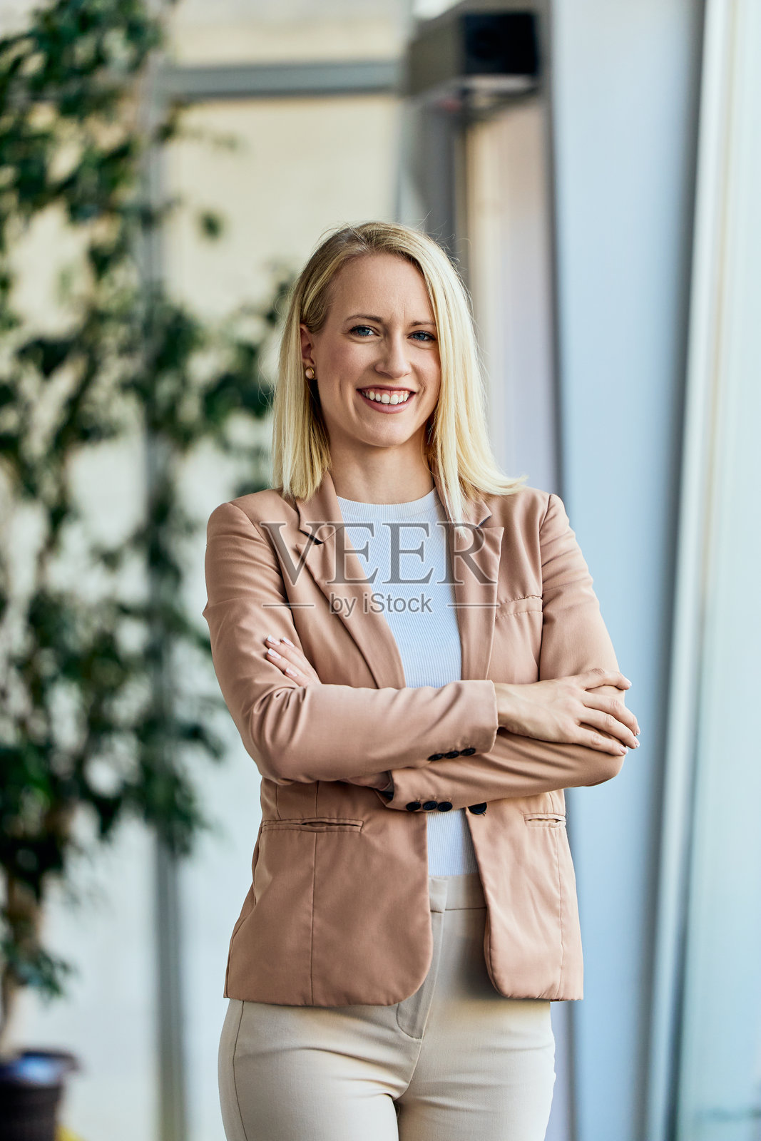 自信的职业女性在现代办公室环境中微笑着看向镜头照片摄影图片